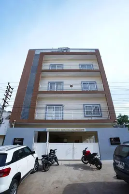 two motorcycles parked in front of a building at Samruddhi Service Apartments in Mysore
