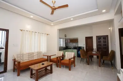 a living room with a couch and a ceiling fan at Samruddhi Service Apartments in Mysore