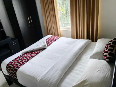 a bed with a blanket on it in a bedroom at Townhouse Kozhikode Beach Formerly Point Avenue in Kozhikode