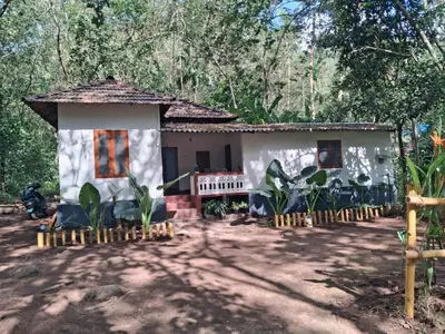 a small house with chairs in front of it at Pookie stay athirapilly in Athirappilly