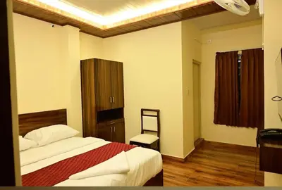 a bedroom with a bed and a chair in it at Ridhis Stay in Virajpet