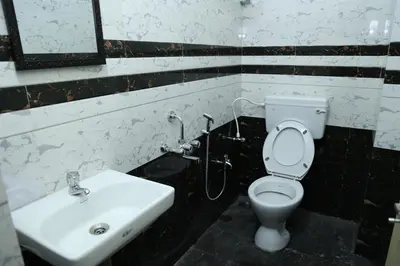 a bathroom with a toilet and a sink at Hotel Aranmanai in Coimbatore