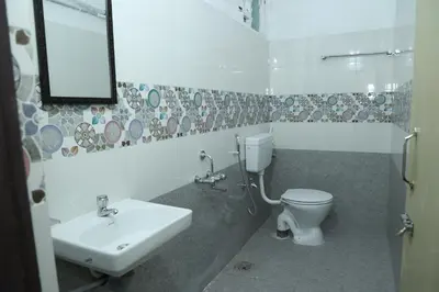 a bathroom with a sink and a toilet at Hotel Aranmanai in Coimbatore