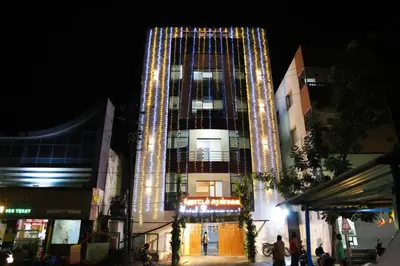 a tall building with lights on it at night at Hotel Aranmanai in Coimbatore