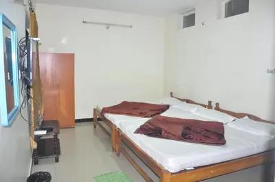 a bedroom with a bed with white sheets at HS Cottage Ooty in Ooty