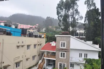 a building with a red roof in a city at HS Cottage Ooty in Ooty