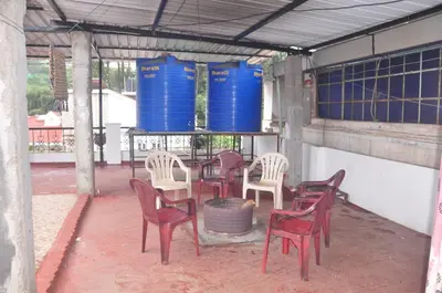 a group of chairs and a table with blue barrels at HS Cottage Ooty in Ooty