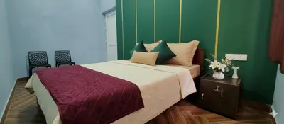 a bedroom with a large bed with green walls at Hanni Resort in Kotagiri