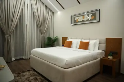 a bedroom with a large white bed with orange pillows at Hills and Hearts Luxury Villa in Coonoor