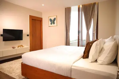 a bedroom with a bed with a television and a window at Hills and Hearts Luxury Villa in Coonoor