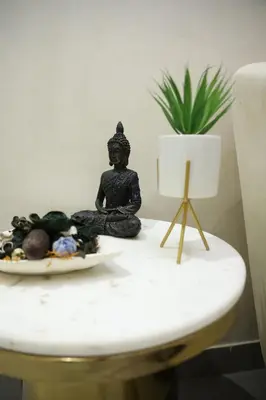 a statue of a buddha sitting on a table at Hills and Hearts Luxury Villa in Coonoor