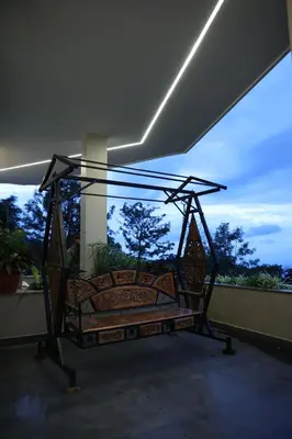 a bed on a balcony with a view of trees at Hills and Hearts Luxury Villa in Coonoor