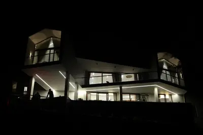 a building at night with a person standing in front of it at Hills and Hearts Luxury Villa in Coonoor