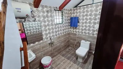a bathroom with a toilet and a sink at Nature's Spark Resort in Sivasamudram