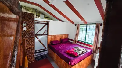 a small bed in a room with a window at Nature's Spark Resort in Sivasamudram