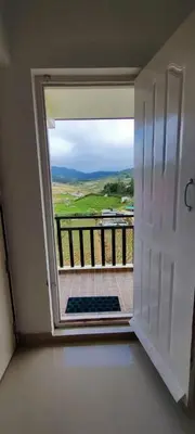 a door open to a balcony with a view at Noori Home Stay - 2BH in 1st Floor Near Ooty in Ooty