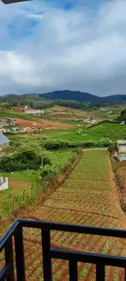 a view of a field from a balcony at Noori Home Stay - 2BH in 1st Floor Near Ooty in Ooty