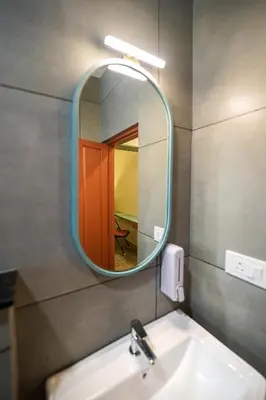 a bathroom with a sink and a mirror at Sreenivas Lodge by Copperfolia in Kozhikode