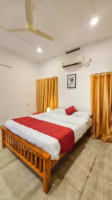 a large bed in a room with yellow curtains at TS Club in Trichūr