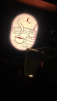 a lit up sign with a bowl and a drink at TS Club in Trichūr