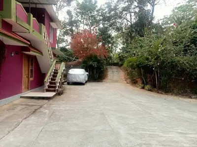 an empty street next to a pink building at Somanna Estate stay in Madikeri