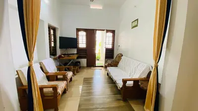 a living room with couches and chairs and a television at Green Island homestay in Kadalundi