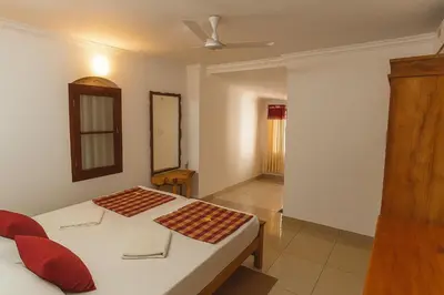 a bedroom with two beds and a mirror at Haris Farm House in Kannur