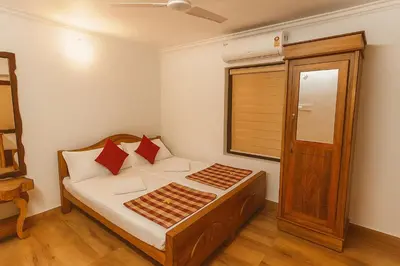 a bedroom with a bed and a window and a door at Haris Farm House in Kannur
