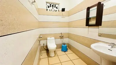 a bathroom with a toilet and a sink at Haris Farm House in Kannur