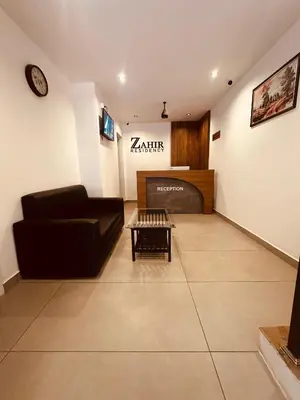 a living room with a couch and a table at ZAHIR RESIDENCY calicut in Kozhikode