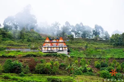 a house with an orange roof on a hill at Zostel Kodaikanal, Vilpatti in Kodaikānāl