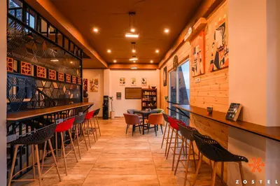 a bar with chairs and a table in a restaurant at Zostel Kodaikanal, Vilpatti in Kodaikānāl