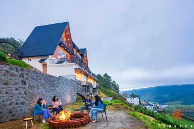a group of people sitting around a fire pit at Zostel Kodaikanal, Vilpatti in Kodaikānāl