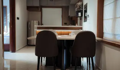 a kitchen with a table and two black chairs at French Boulevard in Mahe