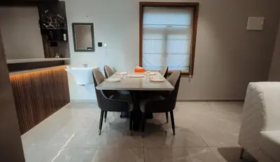 a dining room with a table and chairs and a bathroom at French Boulevard in Mahe
