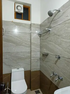 a bathroom with a shower with a toilet and a sink at RF Tower Lodge in Kozhikode