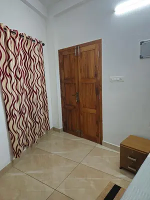 a room with a wooden door and a wall at RF Tower Lodge in Kozhikode
