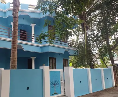 a blue house with a white fence in front of it at ILANJI TREE Inn in Cochin