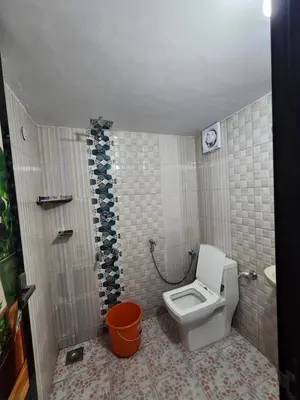 a small bathroom with a toilet and a shower at ILANJI TREE Inn in Cochin