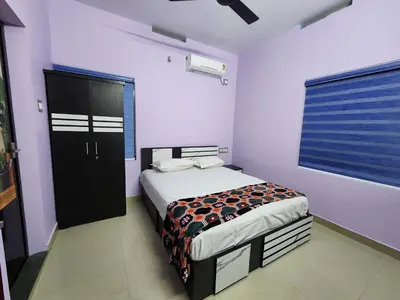 a bedroom with a bed and a large window at ILANJI TREE Inn in Cochin