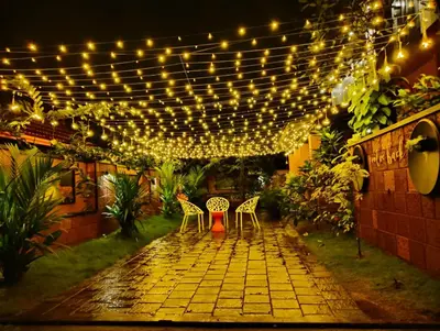 a patio with a string of lights and chairs at Skylark Home in Mananthavady