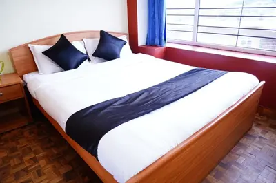 a large bed in a room with a window at KP Holidays తెలుగు Cottage in Ooty