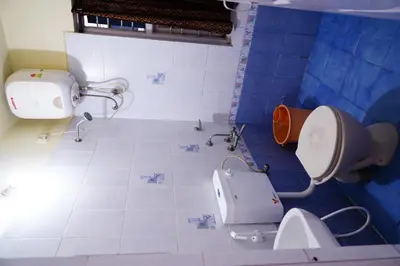 a blue and white bathroom with a toilet at KP Holidays తెలుగు Cottage in Ooty