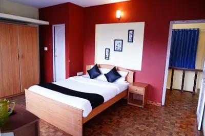 a bedroom with a large bed with red walls at KP Holidays తెలుగు Cottage in Ooty