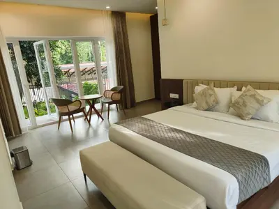 a hotel room with a bed and a balcony at Half Moon Resort Vythiri by Z Vacations in Vayittiri