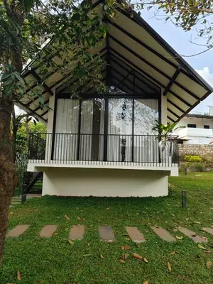 a small house with a balcony in a yard at Half Moon Resort Vythiri by Z Vacations in Vayittiri