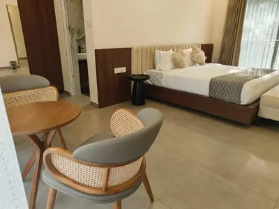 a bedroom with a bed and a table and chairs at Half Moon Resort Vythiri by Z Vacations in Vayittiri