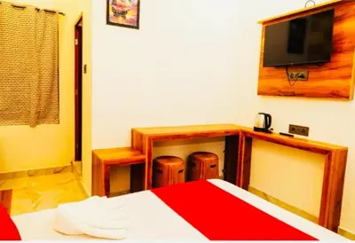 a bedroom with a bed and a tv on the wall at Aps inn munnar in Munnar