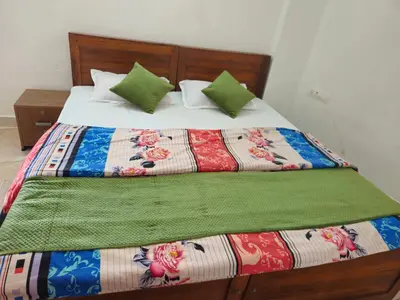 a bed with a colorful comforter and pillows on it at RF Tower Lodge in Kozhikode