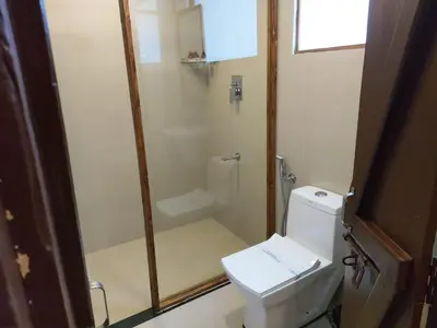 a bathroom with a shower and a white toilet at 36 Palms Heritage Villa in Cochin